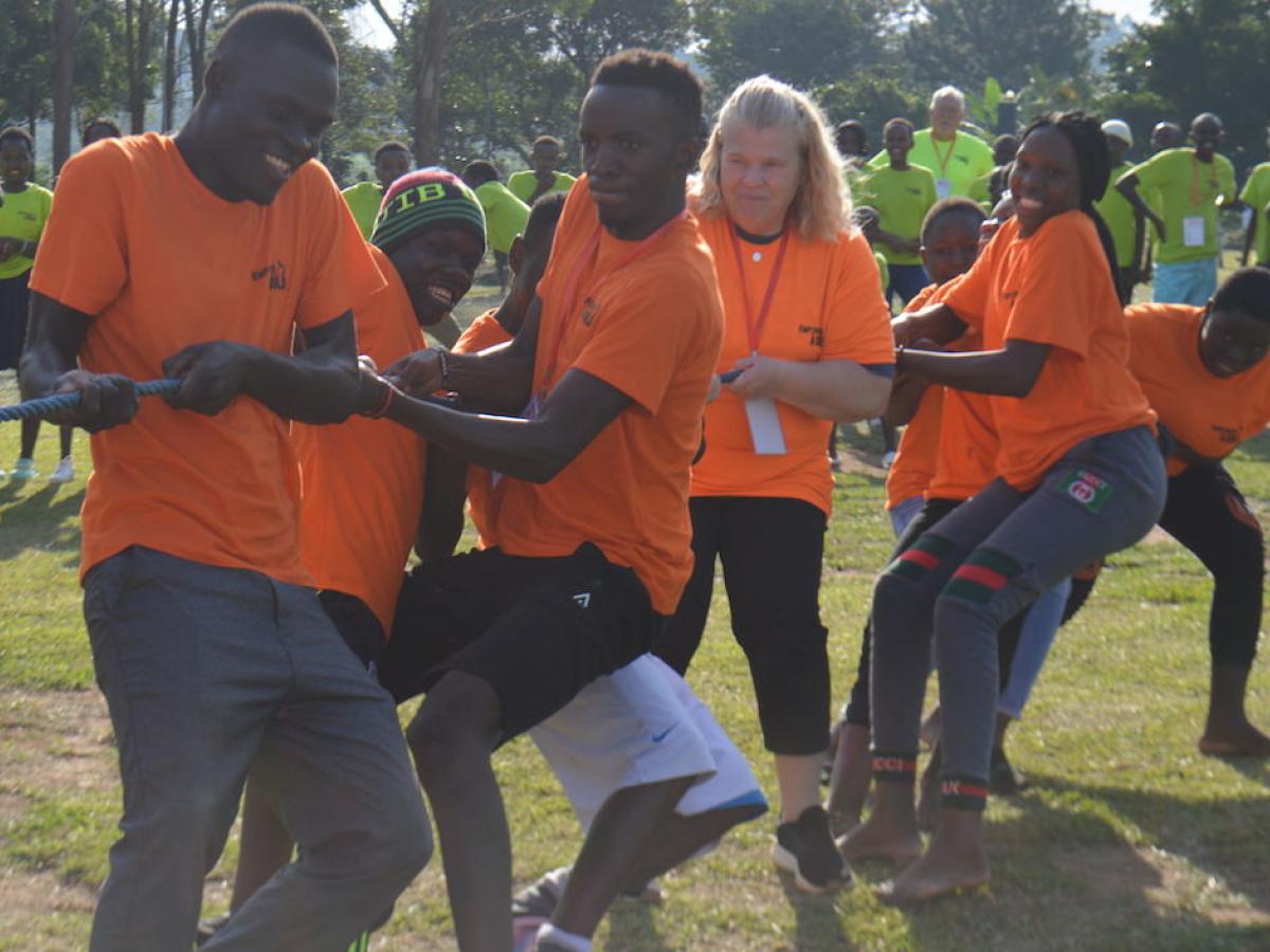 Volunteers and young people playing Tug of War